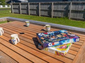 An outdoor table with board games and cups at Whangamata