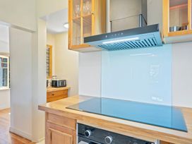 A kitchen with a toaster and glass cooktop at Ocean Breeze Cottage - Paekakariki Holiday Home