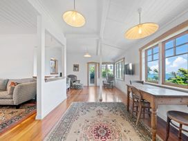 A living room with a sofa, table, and television at Ocean Breeze Cottage - Paekakariki Holiday Home