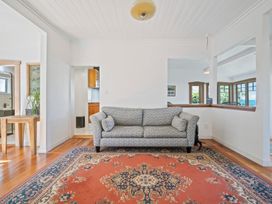 A living room with a sofa and rug at Ocean Breeze Cottage - Paekakariki Holiday Home