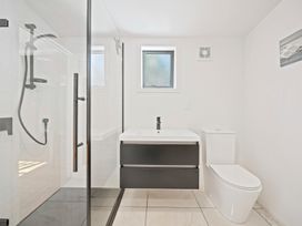A bathroom with a shower, sink, and toilet at Ocean Breeze Cottage - Paekakariki Holiday Home