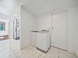 A laundry room with a washing machine and sink at Ocean Breeze Cottage - Paekakariki Holiday Home