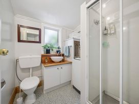 A bathroom with a shower and toilet at Bellbird House - Paekakariki