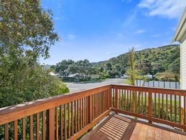 A balcony view overlooking a road and mountains at Bellbird House - Paekakariki