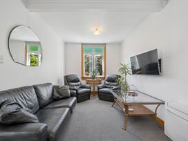 A living room with a sofa and armchairs at Bellbird House - Paekakariki Holiday Home, Paekakariki