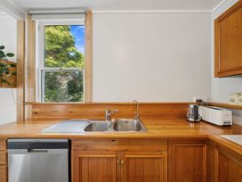 A kitchen with a sink and appliances at Bellbird House - Paekakariki