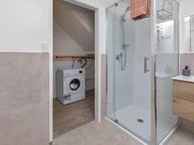 A bathroom with a shower and washing machine at Whangarei
