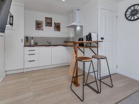 A kitchen with bar stools and kitchen appliances at Whangarei