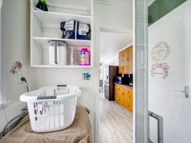 A laundry room with shelves and a laundry basket at Napier