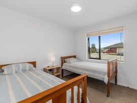 A bedroom with two beds and a nightstand at Home Away From Home - Ruakaka