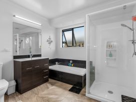 A bathroom with a bathtub and shower at Home Away From Home - Ruakaka
