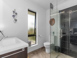 A bathroom with a sink, toilet, and shower at Home Away From Home - Ruakaka