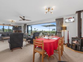 A living room with a sofa and dining table at Home Away From Home - Ruakaka