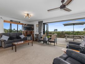 A living room with a sofa and television at Home Away From Home - Ruakaka
