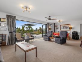 A living room with a coffee table and armchairs at Home Away From Home - Ruakaka