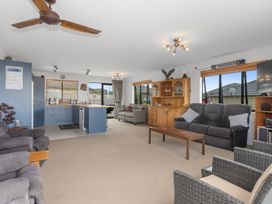 A living room with furniture and kitchen area at Home Away From Home - Ruakaka