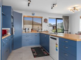 A kitchen with blue cabinets and appliances at Home Away From Home - Ruakaka