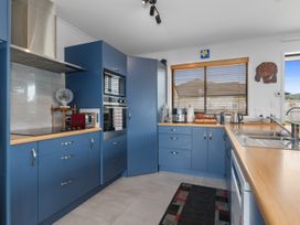 A kitchen with blue cabinets and appliances at Home Away From Home - Ruakaka