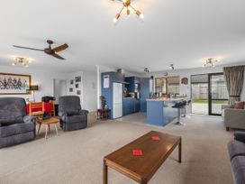 A living room with recliner chairs and kitchen island at Home Away From Home - Ruakaka