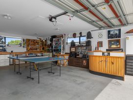 A garage with a ping pong table and tool storage at Home Away From Home - Ruakaka