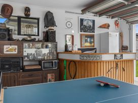 A garage with a bar and a ping pong table at Home Away From Home - Ruakaka