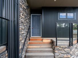 Entrance with steps, stone wall, door, and window at Lake Taupo Holiday Home in Lake Taupo