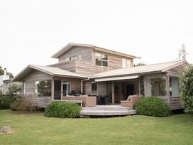 A house with a porch and garden at Tranquil Waterfront Getaway - Point Wells Warkworth