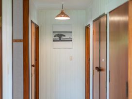 A hallway with doors and wall art at Whitianga Holiday Home in Whitianga
