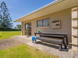 An outdoor area with a table and bench at Whitianga Holiday Home in Whitianga