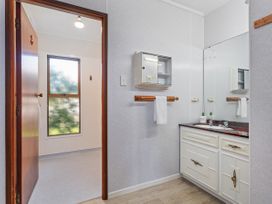 A bathroom with a sink and cabinet at Whitianga Holiday Home, Whitianga