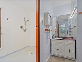A bathroom with shower and sink at Whitianga Holiday Home in Whitianga