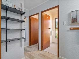 A hallway with doors and a shelf at Whitianga Holiday Home in Whitianga