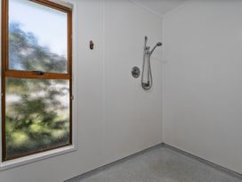 A bathroom with a shower and a window at Whitianga Holiday Home in Whitianga