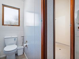 A bathroom with a toilet and a shower area at Whitianga Holiday Home in Whitianga