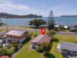 An aerial view of houses near water at Whitianga Holiday Home in Whitianga