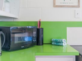 A kitchen counter with a microwave and towels at Whitianga Holiday Home in Whitianga