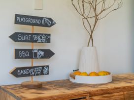 A decorative signpost with directions and a fruit bowl at Whitianga Holiday Home in Whitianga