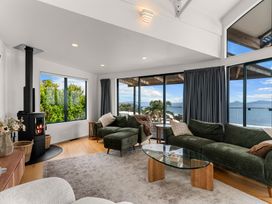 A living room with a fireplace and views at Langscape - Langs Beach Holiday Home Langs Beach