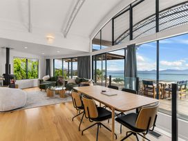 A living room with a sofa and dining table at Langscape - Langs Beach Holiday Home Langs Beach