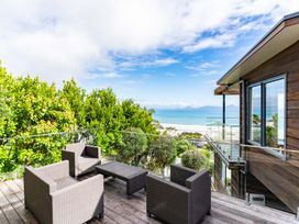 An outdoor seating area with chairs and a table at Langscape - Langs Beach Holiday Home, Langs Beach
