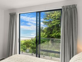 A bedroom with a window overlooking the ocean at Langscape - Langs Beach Holiday Home in Langs Beach