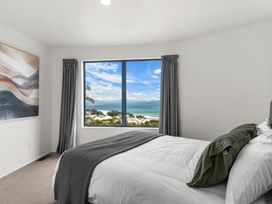 A bedroom with a bed and a window overlooking the ocean at Langscape - Langs Beach Holiday Home Langs Beach