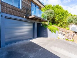 An outdoor area with a garage door and balcony at Langscape - Langs Beach Holiday Home Langs Beach