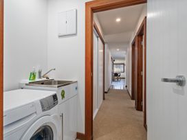 A laundry room with a washing machine and sink at Tairua Holiday Home Tairua