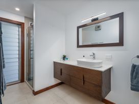 A bathroom with a shower and sink at Tairua Holiday Home in Tairua