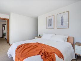 A bedroom with a bed and nightstand at Tairua Holiday Home in Tairua