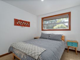 A bedroom with a bed and window at Tairua Holiday Home in Tairua