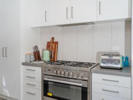 A kitchen with stove and appliances at Tairua Holiday Home in Tairua