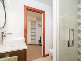 A bathroom with a sink, toilet and shower at Tairua Holiday Home in Tairua