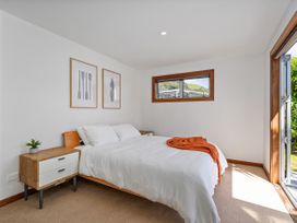 A bedroom with a bed and nightstand at Tairua Holiday Home in Tairua
